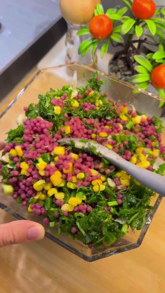Tossing the vibrant purple couscous salad with a lemon dressing.
