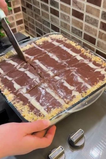 A tall slice of chocolate layer cake with whipped cream and glossy cocoa sauce.