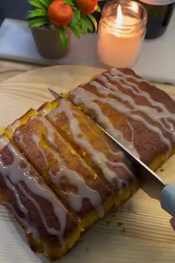 A moist slice of whole orange cake glazed with citrus syrup on a white plate.