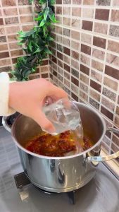 Adding dried mint and red pepper flakes to the meat base.