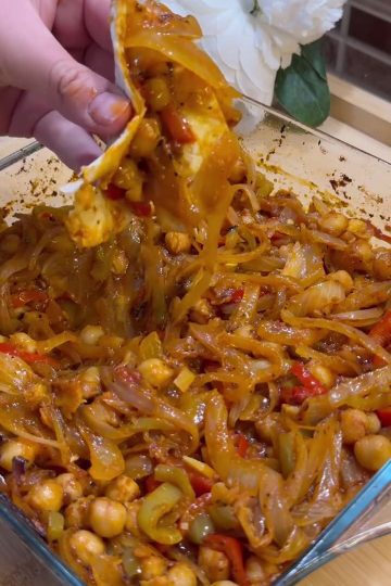 A vibrant plate of Turkish roasted chickpeas and vegetables with fresh lavash and herbs.