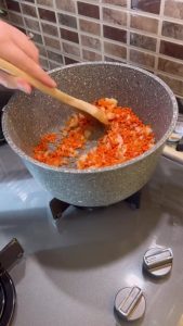 Adding red lentils to a sautéed onion and flour base.
