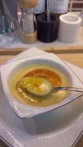 Pouring sizzling red pepper butter over a bowl of Çeşmi Nigar.