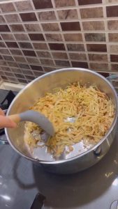 Golden brown sautéed Turkish egg noodles in a pot.