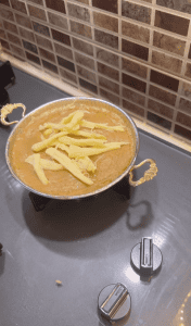 Adding a handful of string cheese to the bubbling cornmeal base.