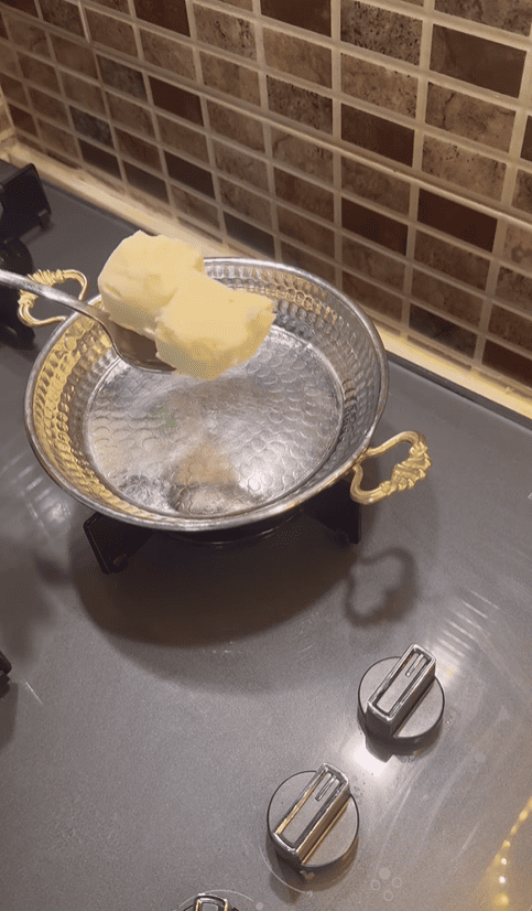 Melting a large knob of butter in a traditional Turkish copper pan.