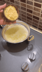 Sautéing cornmeal in butter until golden for Turkish Kuymak.