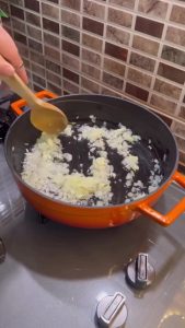 Sautéing onions and garlic in a deep skillet.