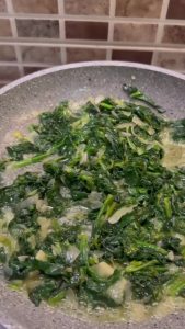Sautéed spinach cooling in a pan.