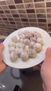 Small marble-sized meatballs coated in white flour in a tray.