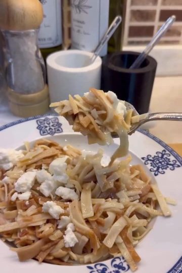 A plate of golden toasted Turkish egg noodles topped with crumbled cheese and browned butter.