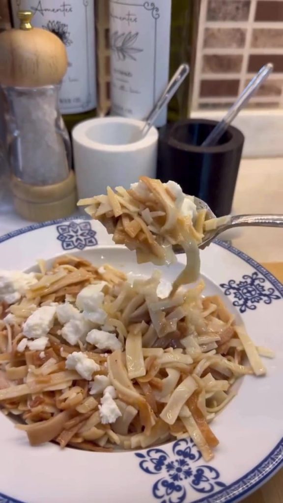 A plate of golden toasted Turkish egg noodles topped with crumbled cheese and browned butter.